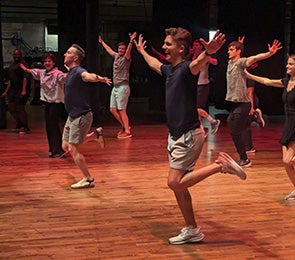 Take It From The Top: People rehearsing a dance routine on a wooden stage.